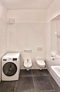梅拉诺Rosa Apartment with parking historic city center的白色的浴室设有洗衣机和卫生间。