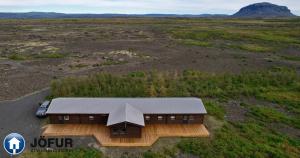 海拉Langahlíð Guesthouse - Privatete Forest -的田野上房子的头顶景色