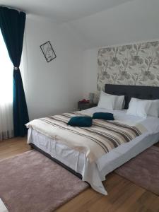 霍雷祖Casuta din Gradina的卧室配有带蓝色枕头的大型白色床