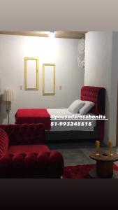 普腊亚罗萨Pousada Rosa Bonita的客厅配有床和红色沙发