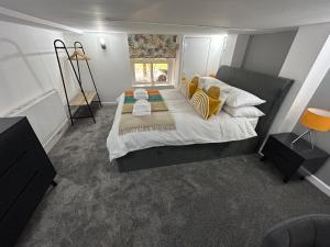 曼彻斯特Airport Hideaway的一间卧室配有一张带黄色和白色枕头的大床