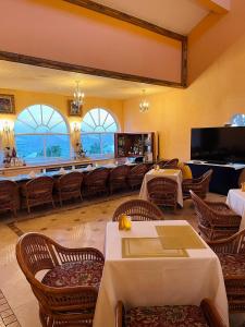 Mount Pleasant可可礁百慕达酒店的一间带桌椅的餐厅和一间大房间