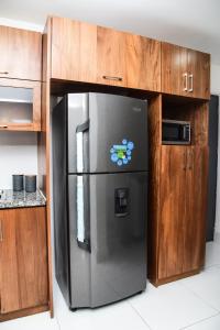 圣地亚哥洛斯卡巴Torre Real VI的带木柜的厨房内的不锈钢冰箱