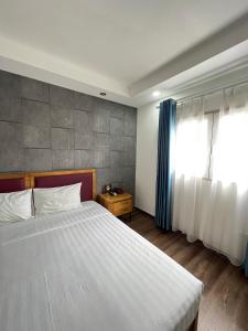 河内Holiday Suites Hotel & Spa的一间卧室设有一张大床和一个窗户。