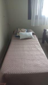 圣萨尔瓦多德朱Chalet del Rosedal的卧室内的一张床铺,上面有枕头