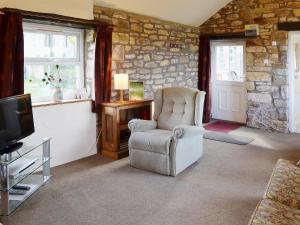 EdlinghamGarden Cottage的客厅配有椅子和电视