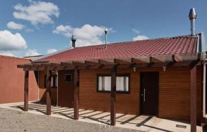 圣若阿金Casa do Guiga的一座带红色屋顶的小木房子