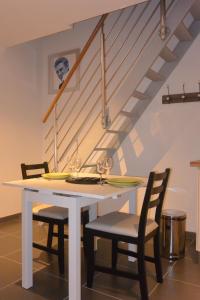 La Membrolle-sur-Choisille舒瓦西尔公寓的餐桌、两把椅子和楼梯