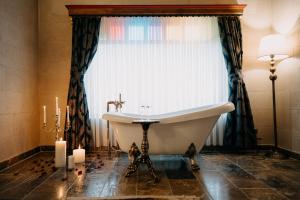乌奇希萨尔博物馆酒店的带浴缸的浴室和带蜡烛的窗户。