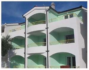 波达卡apartmani Natali的一座高大的白色建筑,设有绿色的阳台