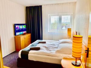 斯武普斯克Słupsk forest PREMIUM HOTEL BUSINESS APARTAMENT M7 - Kaszubska street 18 - Wifi Netflix Smart TV50 - two bedrooms two extra large double beds - up to 6 people full - pleasure quality stay的酒店客房,配有床和电视