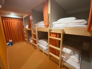 神户安克雷奇旅舍的带三张双层床和毛巾的客房