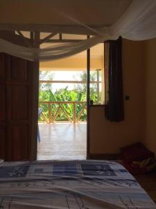 姆托瓦姆布The Hondo Hondo House, Mto wa Mbu的一间卧室设有一张床,享有门廊的景色