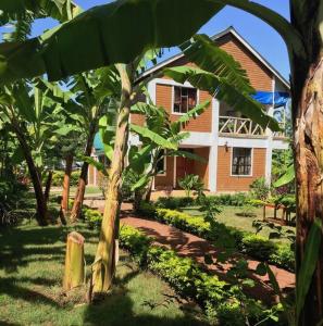 姆托瓦姆布The Hondo Hondo House, Mto wa Mbu的前面有棕榈树的房子