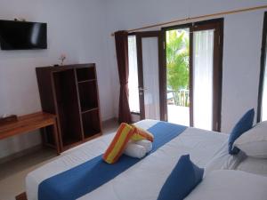 珀尼达岛Japa Bungalow的一间卧室配有一张床、一台电视和一张四柱床。