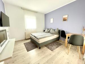 菲拉赫SmartRooms24的一间卧室配有一张床、一张桌子和一台电视