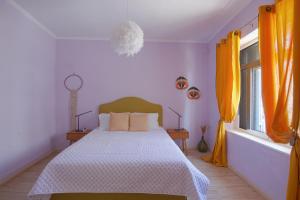 穆兹罗斯FULLHOUSE Moudros的一间卧室配有床,两扇窗户配有橙色窗帘