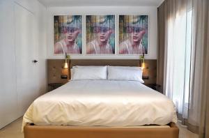莱斯卡瑟斯-达尔卡纳Les Cases del Mar的卧室配有一张床,墙上挂有绘画作品