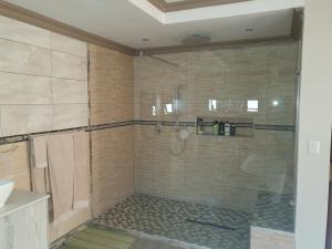 MatsaphaGoggas Nest BNB & Restaurant的浴室里设有玻璃门淋浴