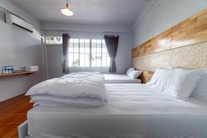 勿洞J Cube Betong - Private House的一间卧室设有两张带白色床单的床和窗户。
