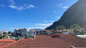莫尼兹港Sea and Sun 4 You - Porto Moniz的享有红色屋顶的城镇和山脉的景色