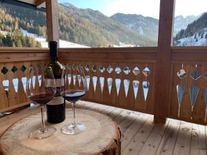 圣马蒂诺-因巴迪亚Lüch dl Finatzer的阳台上的桌子和两杯葡萄酒