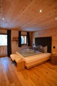 圣马蒂诺-因巴迪亚Lüch dl Finatzer的小木屋内一间卧室,配有一张大床