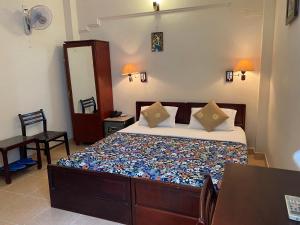 胡志明市金酒店 的一间卧室配有一张床、一张桌子和一面镜子