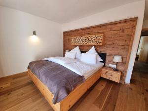 富尔普梅斯Ferienlandhaus Höfer的一间卧室设有一张大床和木墙
