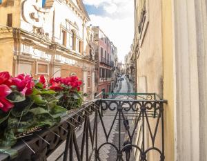 萨萨里维托里奥埃马努埃莱酒店的城市街道上的阳台,有红玫瑰