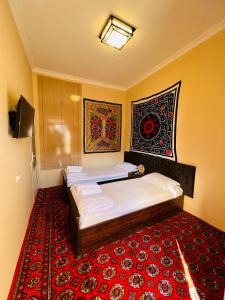 撒马尔罕AL-MOTRUDIY的一间卧室配有两张床,铺有红地毯