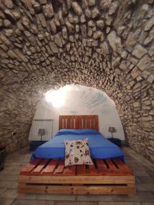 FaetoCasa Vacanze Faeto的卧室配有一张石墙床