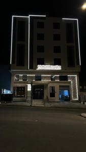 艾卜哈سيفن سون للأجنحة الفندقية的一座在晚上有灯光的建筑