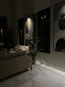 艾卜哈سيفن سون للأجنحة الفندقية的带沙发和盆栽植物的客厅