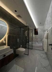 艾卜哈سيفن سون للأجنحة الفندقية的浴室配有卫生间、盥洗盆和浴缸。
