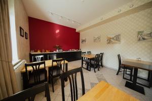 摩拉瓦托普利采Hotel Maj Inn的一间带桌椅和红色墙壁的餐厅