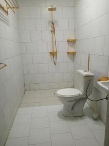 瓦加杜古Le BASTA的白色的浴室设有卫生间和水槽。