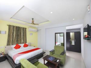 蒂鲁帕蒂Sai Golden Rooms的配有一张床和一把椅子的酒店客房
