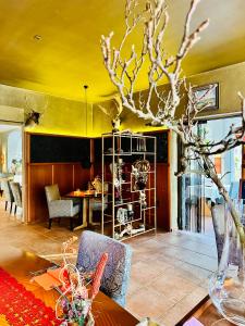 拉德博伊尔ZU DEN LINDEN - RADEBEUL Pension mit Restaurant的一间设有桌子和黄色天花板的用餐室