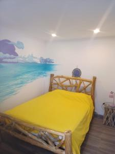 卡帕里卡海岸5th Element Beach House Caparica的一间卧室配有一张木床,墙上挂有绘画作品