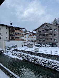 克洛斯特斯TOP LOCATION - Klosters center - 130m distance to ski lift Parsenn Gotschnabahn and railway station Klosters Platz - direct connection to Davos的一群靠近水体的建筑物