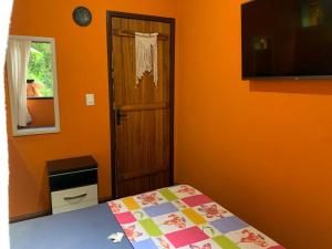 卢米亚Casa em Lumiar - Barulhinho do Rio的一间卧室设有橙色的房间,配有一张床和一扇门