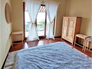 下麦克加诺Nice Home in Maccagno con Pino e Veddasca with garden的一间卧室设有一张床和一个大窗户