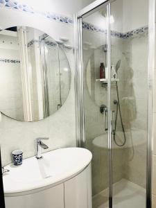 蒙特罗索阿尔马雷Acciuga的带淋浴、盥洗盆和镜子的浴室