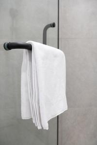 PrigorodnyyСтильный уголок рядом с EXPO - Современный Комфорт的毛巾架上的白色毛巾,挂在淋浴