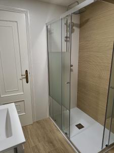 阿尔丹Faro de Aldan的浴室里设有玻璃门淋浴