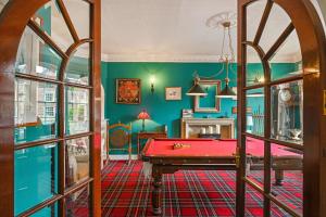 斯泰宁Springwells House的绿色墙壁的房间里一张红色的台球桌