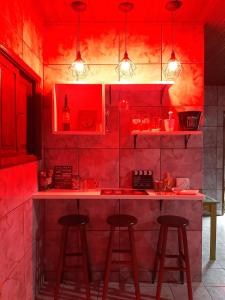 坎普斯戈伊塔卡济斯Casa ampla com Wi-Fi e garagem para dois veículos的红色的厨房,配有一个柜台和两个凳子