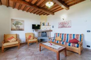 特拉西梅诺湖畔托罗帕鲁金尼乡村民宿的客厅配有沙发、椅子和壁炉