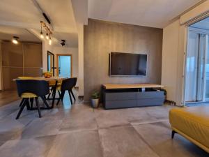 普拉Apartment Matea的客厅配有桌子,墙上配有电视